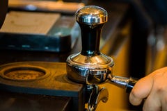 Barista tamps koffiedik in een moderne koffiewinkel stock afbeelding Barista tamps koffiedik in een moderne koffiewinkel stock afbeelding