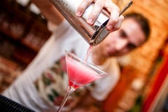 Barman preparing and pouring cosmopolitan alcoholic cocktail stock photos Barman preparing and pouring cosmopolitan alcoholic cocktail stock photos