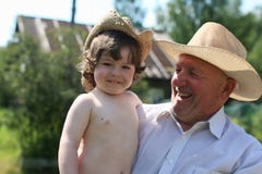 Barn och farfar i cowboyhattar royaltyfria foton Barn och farfar i cowboyhattar royaltyfria foton