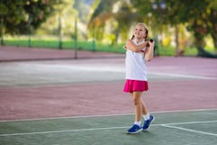 Barn som spelar tennis p? den utomhus- domstolen arkivfoton Barn som spelar tennis p? den utomhus- domstolen arkivfoton