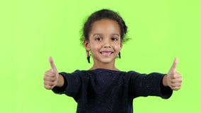 Barnet av en afrikansk amerikan visar upp tummar grön skärm långsam rörelse lager videofilmer Barnet av en afrikansk amerikan visar upp tummar grön skärm långsam rörelse lager videofilmer