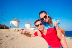 Barnet kopplar ihop framme av väderkvarnar på populärt turist- område på den Mykonos ön, Grekland arkivbilder Barnet kopplar ihop framme av väderkvarnar på populärt turist- område på den Mykonos ön, Grekland arkivbilder