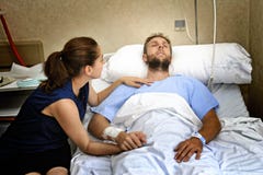 Barnet kopplar ihop på mannen för sjukhusrum som ligger i den säng oroade kvinnan som rymmer hans att bry sig för hand royaltyfri bild Barnet kopplar ihop på mannen för sjukhusrum som ligger i den säng oroade kvinnan som rymmer hans att bry sig för hand royaltyfri bild