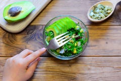 Barnet äter en sallad Barnet rymmer en gaffel i hans hand Sallad med den nya avokadot, grönsallatsidor, på burk havre royaltyfri foto Barnet äter en sallad Barnet rymmer en gaffel i hans hand Sallad med den nya avokadot, grönsallatsidor, på burk havre royaltyfri foto