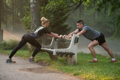 Barnpar som sträcker, innan att köra i skogsbevuxen skog royaltyfria bilder Barnpar som sträcker, innan att köra i skogsbevuxen skog royaltyfria bilder
