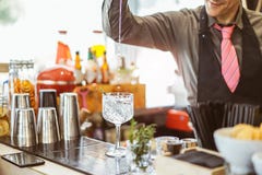 Bartender som blandar en coctail i ett kristallexponeringsglas i en amerikansk st?ng - h?llande alkohol f?r bartender i ett expon arkivbilder Bartender som blandar en coctail i ett kristallexponeringsglas i en amerikansk st?ng - h?llande alkohol f?r bartender i ett expon arkivbilder