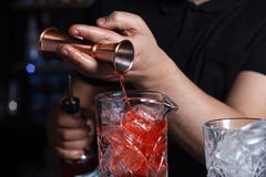 Bartendern häller alkohol in i ett exponeringsglas från grej arkivfoto Bartendern häller alkohol in i ett exponeringsglas från grej arkivfoto