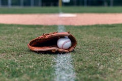 Baseballhandschuh und Ball auf Freiwurflinie stockfoto Baseballhandschuh und Ball auf Freiwurflinie stockfoto