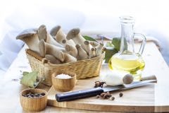Basket with mushrooms, olive oil and ingredients for cooking on the wooden table of the kitchen background Stock Photo Basket with mushrooms, olive oil and ingredients for cooking on the wooden table of the kitchen background Stock Photo