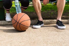 Basket på fot av parsammanträde parkerar på bänken royaltyfria foton Basket på fot av parsammanträde parkerar på bänken royaltyfria foton