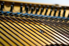 Bass strings strung in the old piano. The mechanism of musical instruments stock photo Bass strings strung in the old piano. The mechanism of musical instruments stock photo