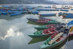 bateaux en bois multicolores sur le lac contre le contexte des montagnes vertes bateaux vides jaunes verts rouges bleus sur l'eau photos libres de droits bateaux en bois multicolores sur le lac contre le contexte des montagnes vertes bateaux vides jaunes verts rouges bleus sur l'eau photos libres de droits