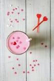 Batido de leche rosado asperjado con los corazones foto de archivo libre de regalías Batido de leche rosado asperjado con los corazones foto de archivo libre de regalías