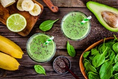 Batido verde saudável com as sementes da banana, do cal, dos espinafres, do abacate e do chia nos frascos de vidro foto de stock royalty free Batido verde saudável com as sementes da banana, do cal, dos espinafres, do abacate e do chia nos frascos de vidro foto de stock royalty free