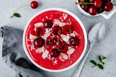 Batido vermelho da cereja com bagas, os flocos da amêndoa e as microplaquetas frescos do coco fotos de stock Batido vermelho da cereja com bagas, os flocos da amêndoa e as microplaquetas frescos do coco fotos de stock
