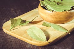 Bay leaf on a tray in a wooden bowl/bay leaf in a wooden plate on a tray, rural style stock photos Bay leaf on a tray in a wooden bowl/bay leaf in a wooden plate on a tray, rural style stock photos