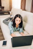 Bbeautiful kvinna som hemma använder bärbar datordatoren på soffan fotografering för bildbyråer Bbeautiful kvinna som hemma använder bärbar datordatoren på soffan fotografering för bildbyråer