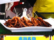 BBQ squids on a disposable container at the festival royalty free stock photos BBQ squids on a disposable container at the festival royalty free stock photos