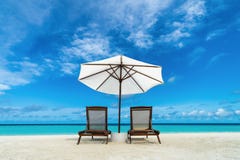 Beach lounger and umbrella on sand beach. Concept for rest, relaxation, holidays, spa, resort.
