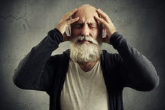 Bearded man holding his head and wincing in pain royalty free stock image Bearded man holding his head and wincing in pain royalty free stock image