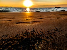 Beau lever de soleil sur un Pebble Beach avec le sable et les pas image stock Beau lever de soleil sur un Pebble Beach avec le sable et les pas image stock