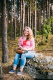 Beau plus la jeune femme de sourire de taille s'asseyant dessus image stock Beau plus la jeune femme de sourire de taille s'asseyant dessus image stock