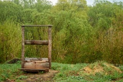 Beau vieux puits en bois dans le village ? l'arri?re-plan photos libres de droits Beau vieux puits en bois dans le village ? l'arri?re-plan photos libres de droits