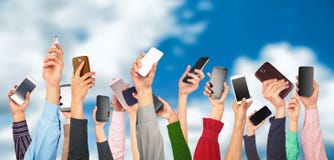Beaucoup de mains tenant des téléphones portables contre Image libre de droits Beaucoup de mains tenant des téléphones portables contre Image libre de droits