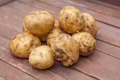 Beaucoup de pommes de terre dans une cuvette sur la table en bois photographie stock libre de droits Beaucoup de pommes de terre dans une cuvette sur la table en bois photographie stock libre de droits