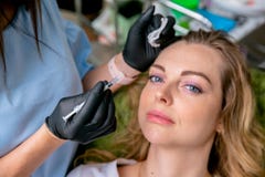Beautician is preparing to inject botulinum toxin in female face. Young woman on cosmetological procedures. Close-up. Beauty and royalty free stock photography Beautician is preparing to inject botulinum toxin in female face. Young woman on cosmetological procedures. Close-up. Beauty and royalty free stock photography