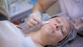 Beautician w rękawiczkach stawia przejrzystego gel na twarzy młoda kobieta zdjęcie wideo Beautician w rękawiczkach stawia przejrzystego gel na twarzy młoda kobieta zdjęcie wideo
