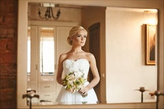 Beautiful And Fashionable Blonde Model Girl With Wedding Hairstyle In Trendy Dress With Bouquet Of Flowers In Her Hands Royalty Free Stock Images Beautiful And Fashionable Blonde Model Girl With Wedding Hairstyle In Trendy Dress With Bouquet Of Flowers In Her Hands Royalty Free Stock Images