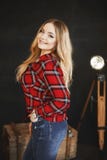 Beautiful And Fashionable Blonde Pluss-size Model Girl With Big Breast In Red Plaid Shirt And In A Jeans, Stands Near The Wooden C Stock Photography