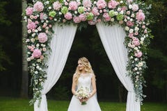 Beautiful And Sensual Blonde Model Girl With Stylish Wedding Hairstyle In A White Fashionable Dress With A Bouquet Of Royalty Free Stock Photos