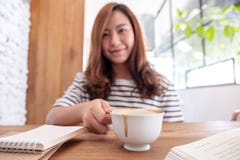 A beautiful asian woman drinking coffee while learning and reading books royalty free stock images A beautiful asian woman drinking coffee while learning and reading books royalty free stock images