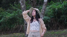 Beautiful Asian woman feeling refreshed and enjoying the nature in the forest. Girl enjoys camping in the forest on vacation. Outd