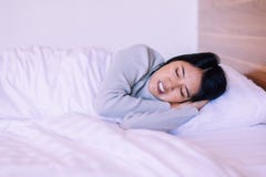 Beautiful Asian Woman Sleeping On Bed And Grinding Teeth,Female Tiredness And Stress Royalty Free Stock Images