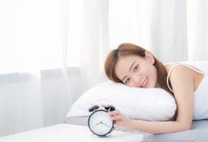 Beautiful Asian Young Woman Turn Off Alarm Clock In Morning, Wake Up For Sleep With Alarm Clock. Stock Image