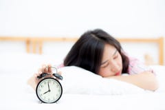 Beautiful Asian Young Woman Turn Off Alarm Clock In Morning, Wake Up For Sleep With Alarm Clock, Relax And Lifestyle Concept. Royalty Free Stock Photos