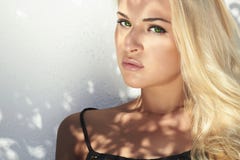 Beautiful blond woman in daylight.shadows on the face.girl near white wall.top model stock photography Beautiful blond woman in daylight.shadows on the face.girl near white wall.top model stock photography