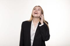 Beautiful blonde business lady in black suit is talking on the mobile phone and smiling royalty free stock image Beautiful blonde business lady in black suit is talking on the mobile phone and smiling royalty free stock image