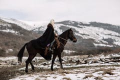 Beautiful blonde Viking in a black cape on horseback royalty free stock image Beautiful blonde Viking in a black cape on horseback royalty free stock image