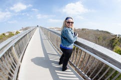 Beautiful blonde woman stands on the elevated boardwalk in Assateague Island stock photo Beautiful blonde woman stands on the elevated boardwalk in Assateague Island stock photo