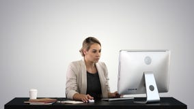 Beautiful blonde woman working on computer on gradient background. stock photo Beautiful blonde woman working on computer on gradient background. stock photo