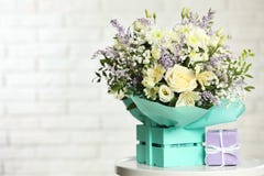 Beautiful Bouquet Of Flowers And Gift Box On Table Against Light Background. Stock Photo Beautiful Bouquet Of Flowers And Gift Box On Table Against Light Background. Stock Photo