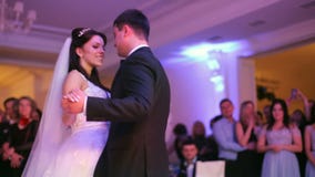 Beautiful bride and handsome groom dancing first dance at the wedding party stock footage Beautiful bride and handsome groom dancing first dance at the wedding party stock footage