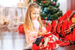 Beautiful child plays a toy in the living room. Concept New Year Stock Photos Beautiful child plays a toy in the living room. Concept New Year Stock Photos