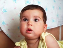 A beautiful dark haired and black eyed baby is watching in the distance royalty free stock image A beautiful dark haired and black eyed baby is watching in the distance royalty free stock image