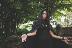 Beautiful dark vampire woman with black mantle and hood Royalty Free Stock Photo Beautiful dark vampire woman with black mantle and hood Royalty Free Stock Photo