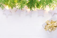 Beautiful elegant Christmas New Year background. White stars sparkling golden lights garland green juniper gift box on plank wood stock photo Beautiful elegant Christmas New Year background. White stars sparkling golden lights garland green juniper gift box on plank wood stock photo
